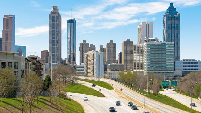 Skyline von Atlanta, Blick auf Hochhäuser, Autobahn und Grün - blauer Himmel und Sonnenschein